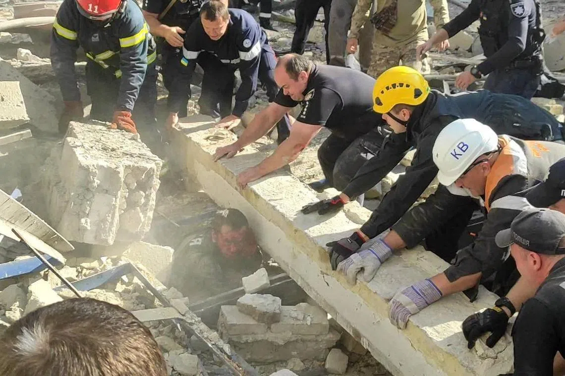 Rescuers work to free a police officer from debris at a site of a Russian missile strike in the central city of Kryvyi Rih.