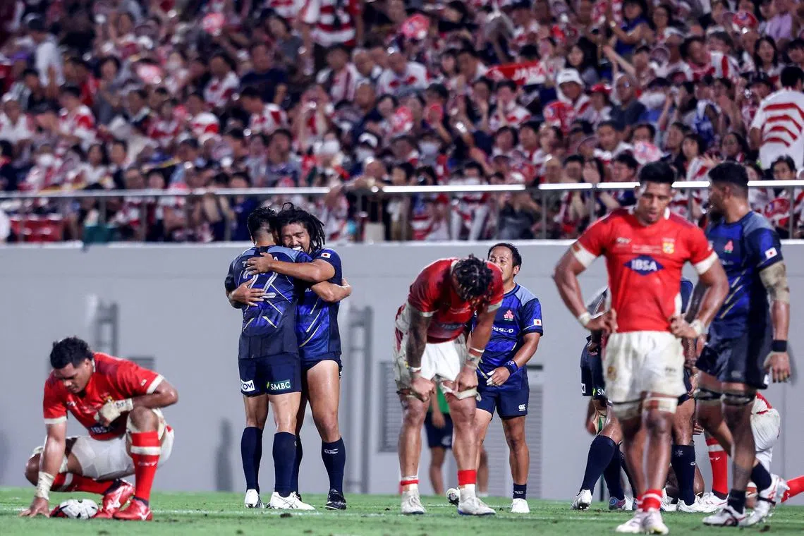 Japan's Rikiya Matsuda embraces Shota Horie after their win against Tonga in Osaka.