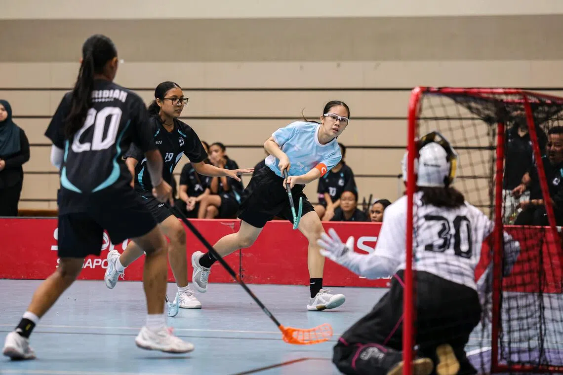 Swiss Cottage Secondary School captain Tan Shayn Min (centre) scoring the team’s first goal against Meridian Secondary School during the C Division girls’ floorball final. She finished with six of her school’s seven goals.