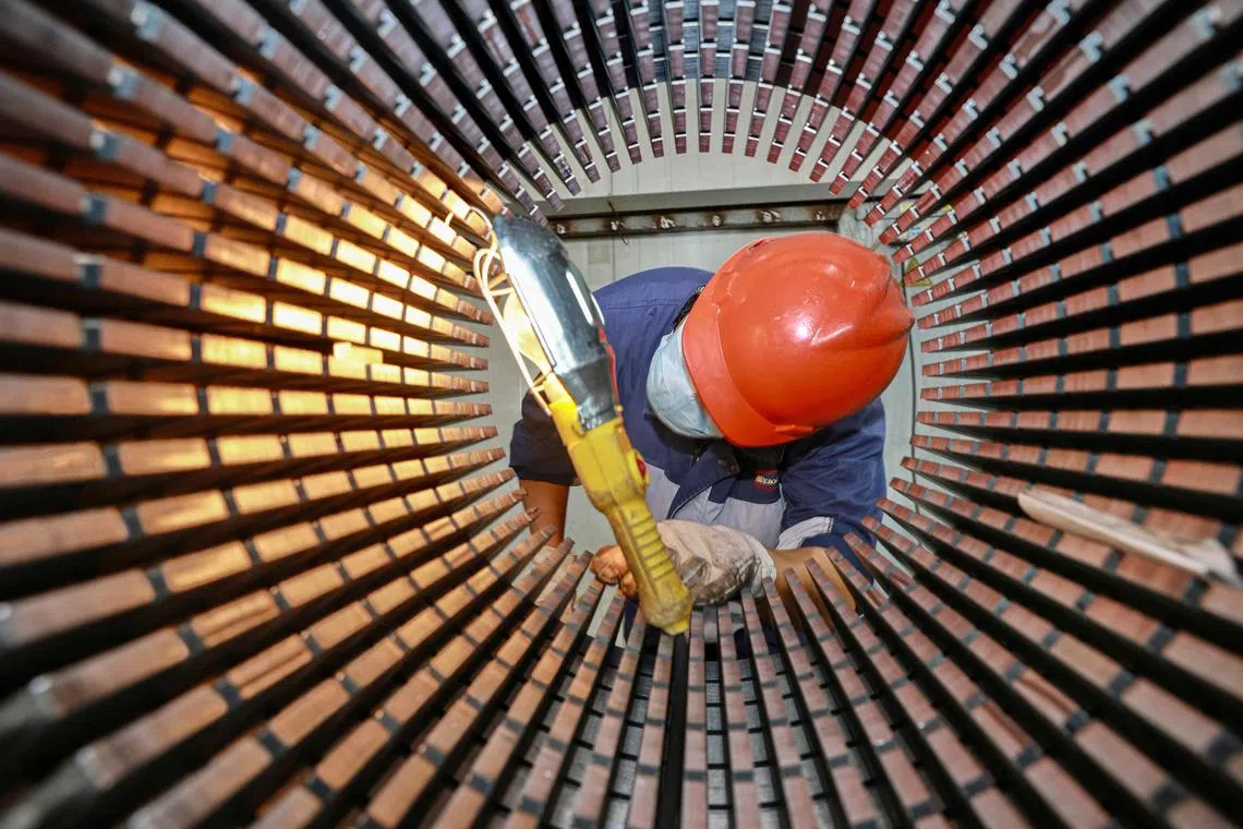 A worker checks a rotor core used for wind turbines at a factory in Nantong, in China's eastern Jiangsu province on September 20, 2023. (Photo by AFP) / China OUT