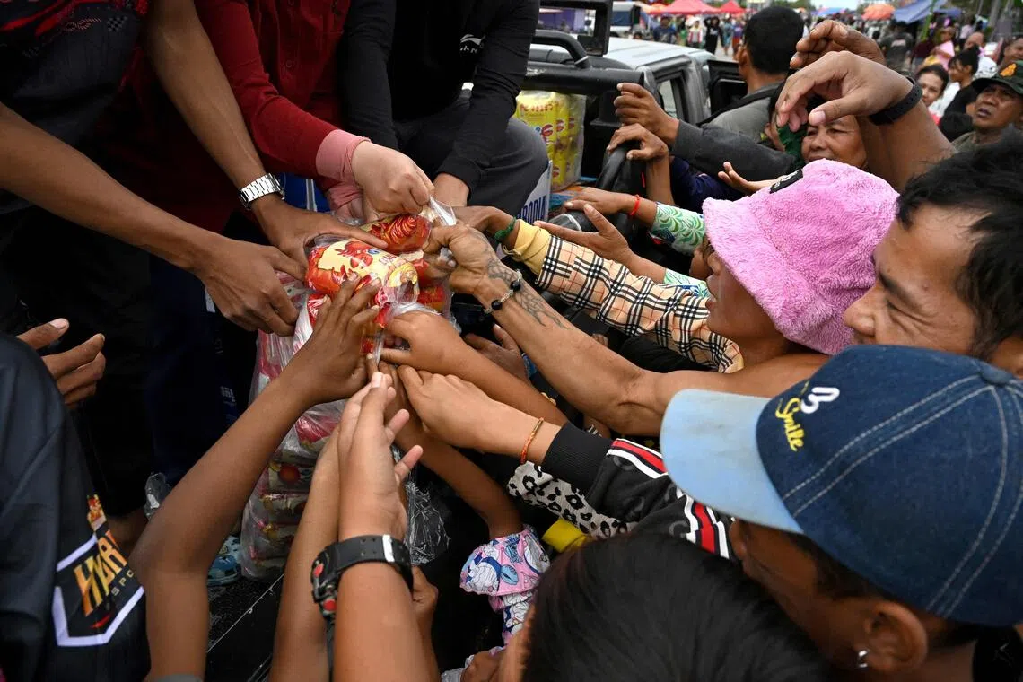 Cambodiands displaced by war gather to receive aid at a temporary camp in Cambodia's Banteay Meanchey province.
