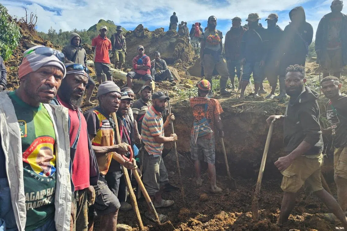 A locals gather amid the damage after a landslide in Maip Mulitaka, Enga province, Papua New Guinea May 24, 2024 in this obtained image. Emmanuel Eralia via REUTERS