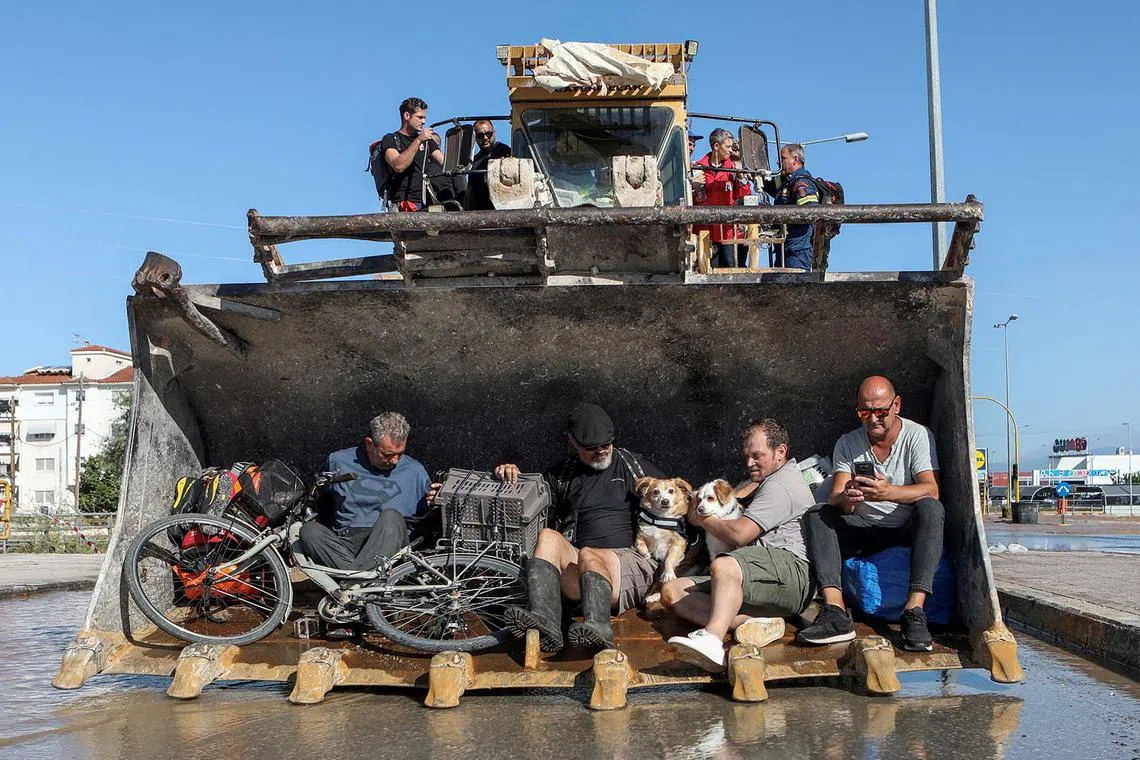 Locals are evacuated on an excavator from a flooded area, in the aftermath of Storm Daniel, in Larissa, Greece, Sept 10.