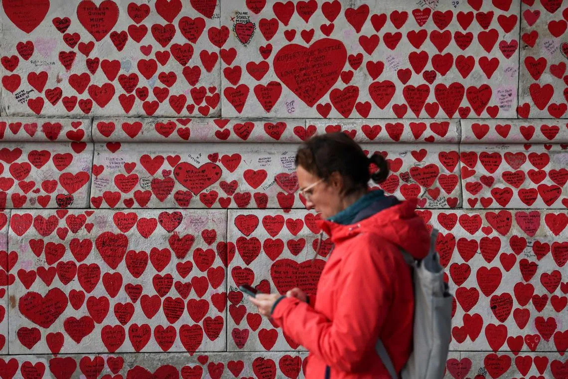 A pedestrian walks past the National Covid Memorial Wall, dedicated to those who lost their lives to Covid-19, in London.