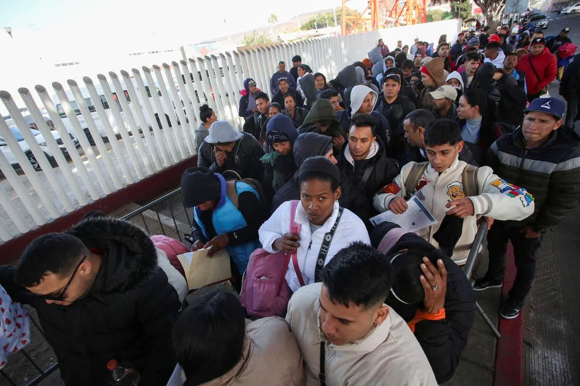 Migrants gather at El Chaparral border crossing after their CBP One app asylum appointment was cancelled on the day of US President Donald Trump's inauguration.
