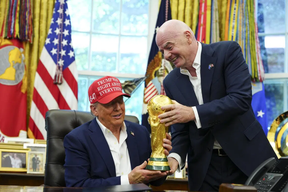 US President Donald Trump (left) holding the Fifa World Cup trophy with Fifa president Gianni Infantino, in the Oval Office of the White House, on Aug 22.