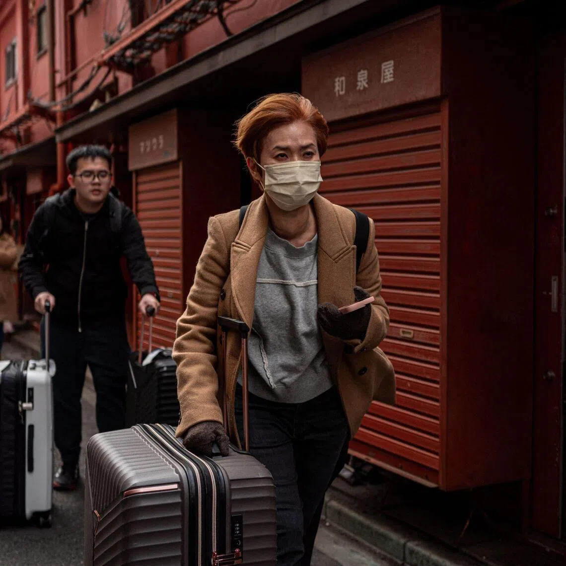 People visit a shopping street in Asakusa district near Sensoji Temple, a popular tourist location in Tokyo.