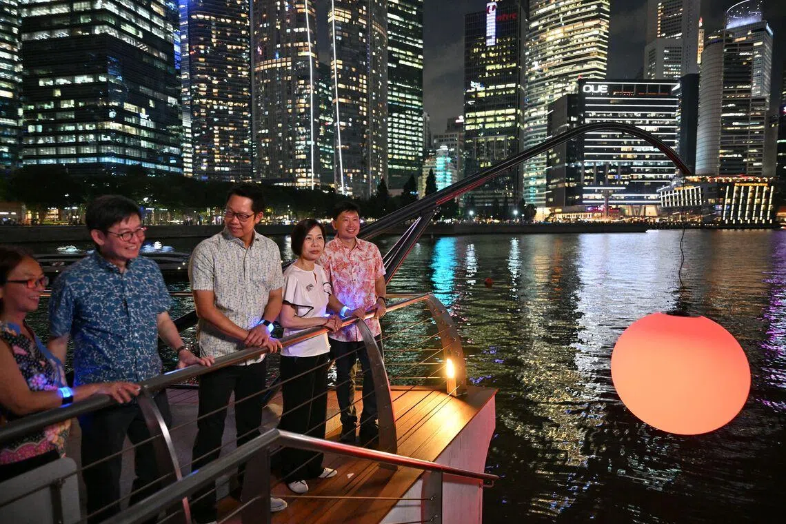 (From right) National Development Minister Chee Hong Tat, URA chairperson Ow Foong Pheng, UOB group chief sustainability officer Eric Lim, URA CEO Lim Eng Hwee and URA’s deputy CEO and chief planner Adele Tan viewing Let’s Fish The Sun, an interactive light art installation by Chinese artist Wentao Wang, at the i Light Singapore festival on June 5.