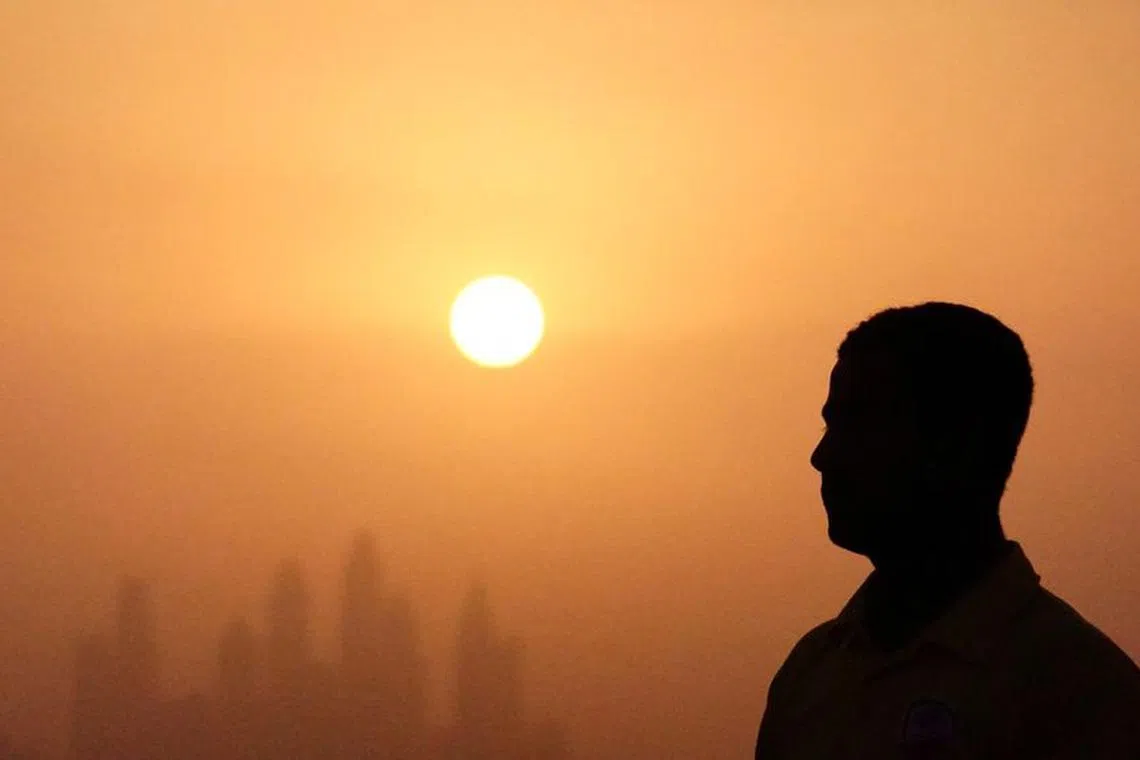 FILE PHOTO: Lifeguard Mohamed stands near a swimming pool while the sun sets over Dubai, United Arab Emirates, August 12, 2023. REUTERS/Amr Alfiky/File Photo