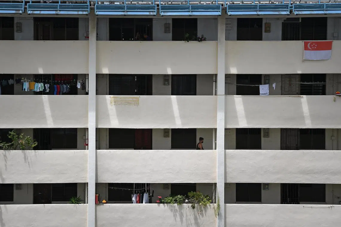 ST20200428_202079217335 Kua Chee Siong/ pixcovid29/ 
12.10pm. Generic pix of a man walking along a corridor as a Singapore flag hangs along the corridor above him at a HDB block in Kim Keat Avenue on 28 April 2020 during the "circuit breaker" period of heightened safe-distancing measures to prevent an escalation of infections of COVID-19. 