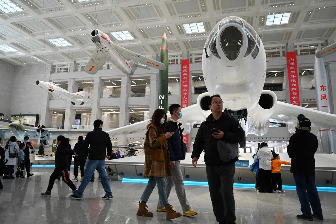 People look at a Chinese H6 bomber and other aircraft at the Military Museum in Beijing on March 3, 2024. (Photo by GREG BAKER / AFP)