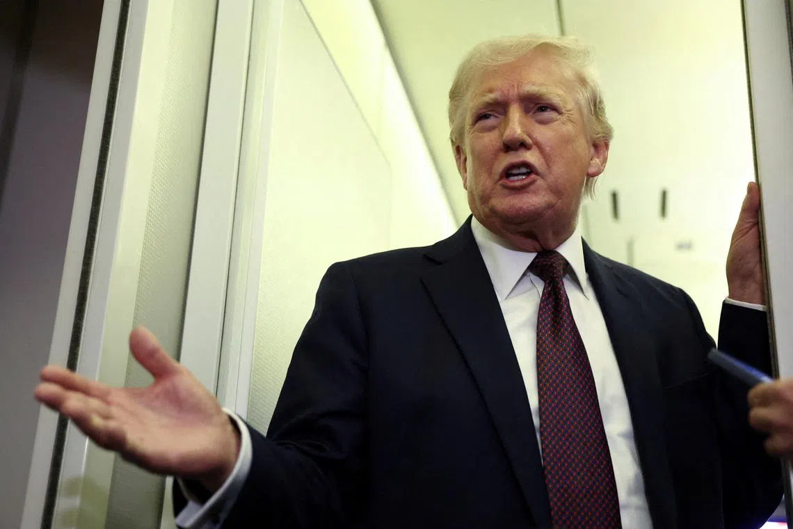 FILE PHOTO: U.S. President Donald Trump speaks to reporters aboard Air Force One on a flight back to Washington March 15, 2026. REUTERS/Kevin Lamarque/File Photo