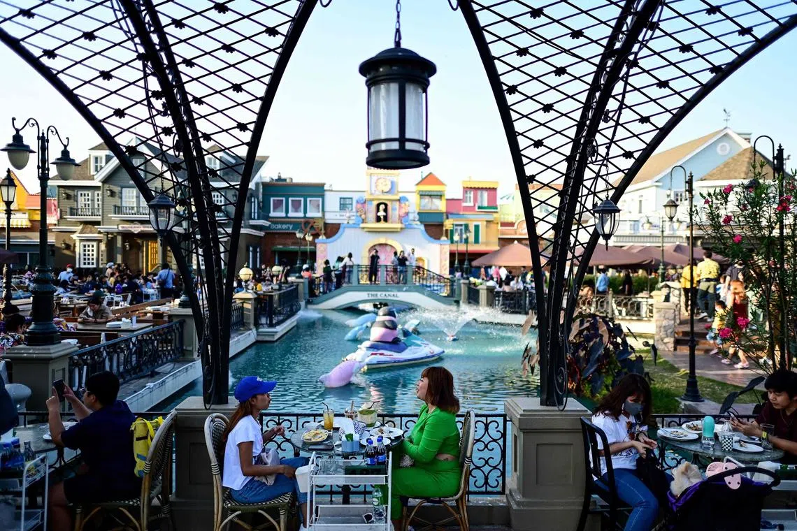 Visitors have a meal at Chocolate Ville, a European village-themed open-air restaurant, on New Years day in Bangkok on January 1, 2023. (Photo by MANAN VATSYAYANA / AFP)