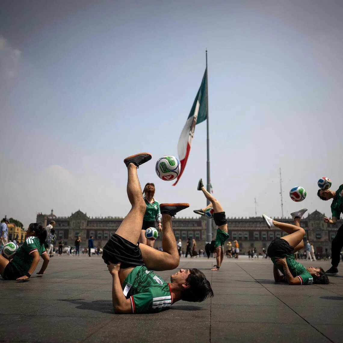 Young people play freestyle with footballs at Zocalo square in Mexico City on March 9, 2026. Mexico will host the opening match of the FIFA 2026 World Cup on June 11, 2026, at the Azteca Stadium in Mexico City. 