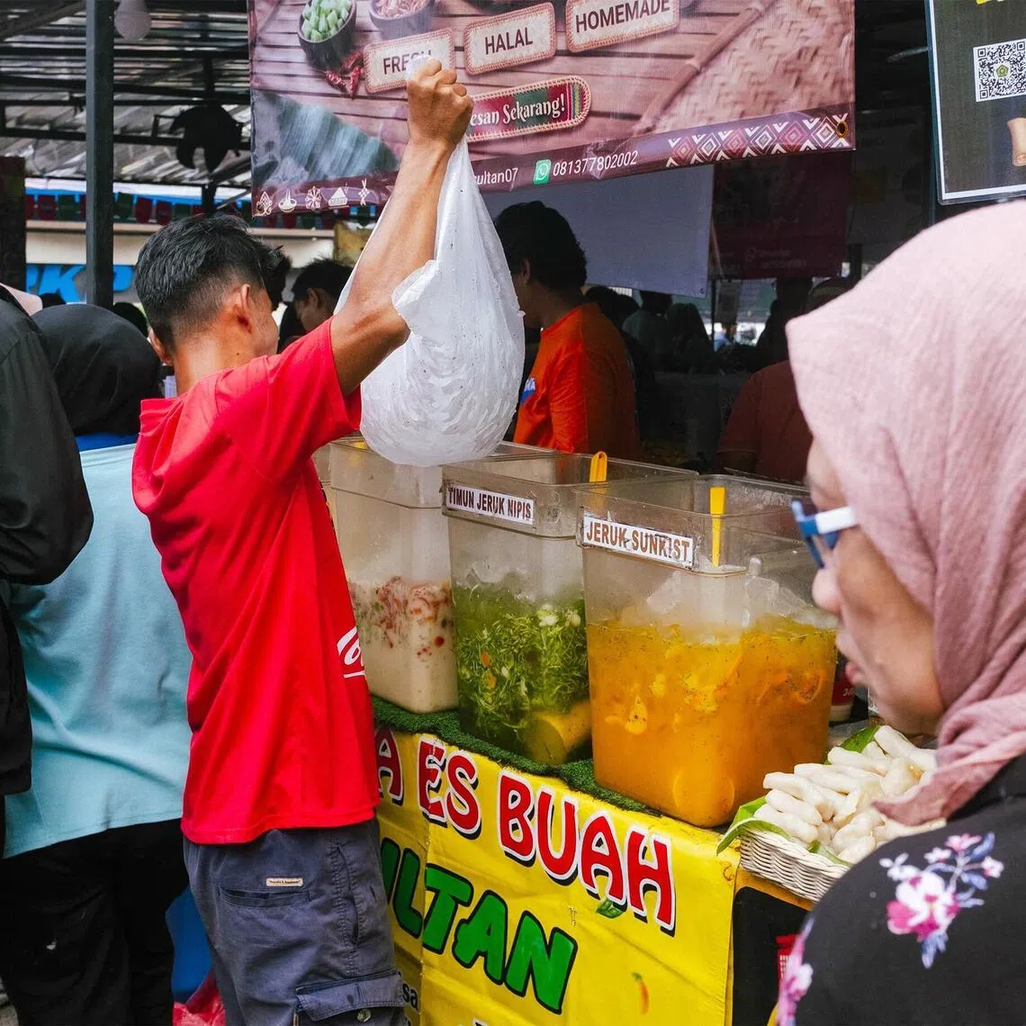 A vendor fills drink containers with ice at the popular takjil market in the Bendungan Hilir neighborhood of Central Jakarta on Feb 25, 2026.
