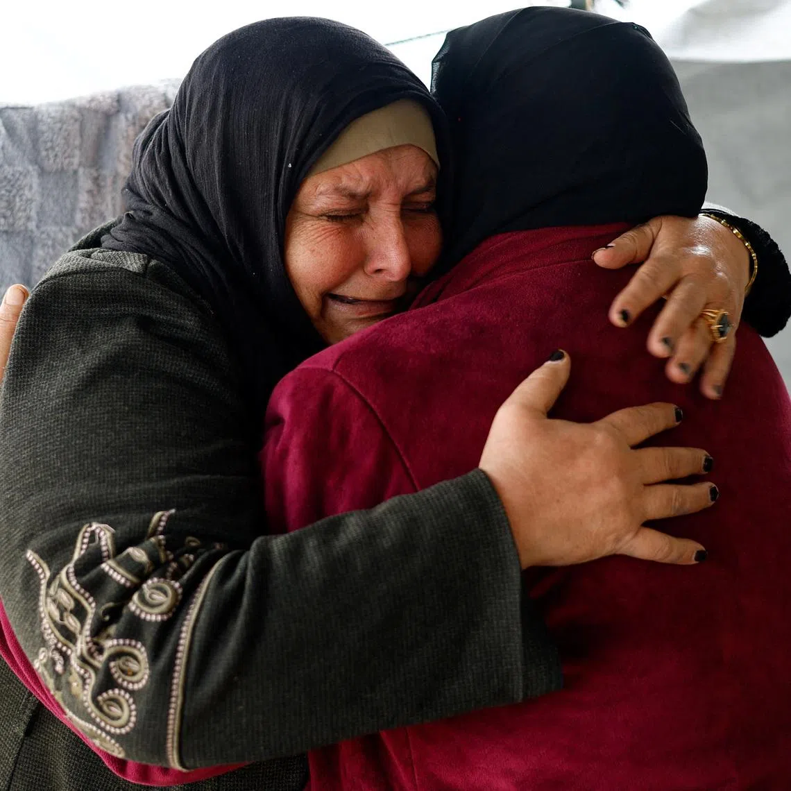 Huda Abu Abed, 56, cries as she is embraced by her sister inside a tent after returning to Gaza through the Rafah crossing, in Khan Younis in the southern Gaza Strip, February 3, 2026. REUTERS/Mahmoud Issa