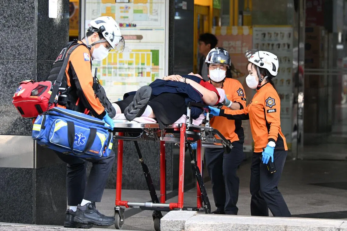 Rescue workers transporting a victim from the scene after a stabbing incident at a supermarket in Incheon on Oct 13.