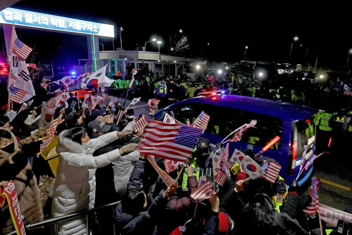 Supporters of impeached South Korean President Yoon Suk Yeol cheer for him as a convoy believed to be carrying Mr Yoon returns him to the Seoul Detention Centre after his court hearing on Jan 18.