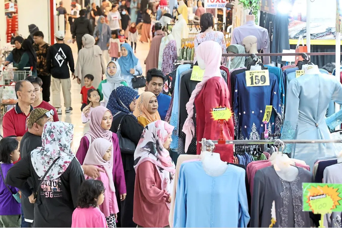 Shoppers looking at the Hari Raya clothes displayed for sale at a booth inside Angsana Johor Bahru Mall. 
