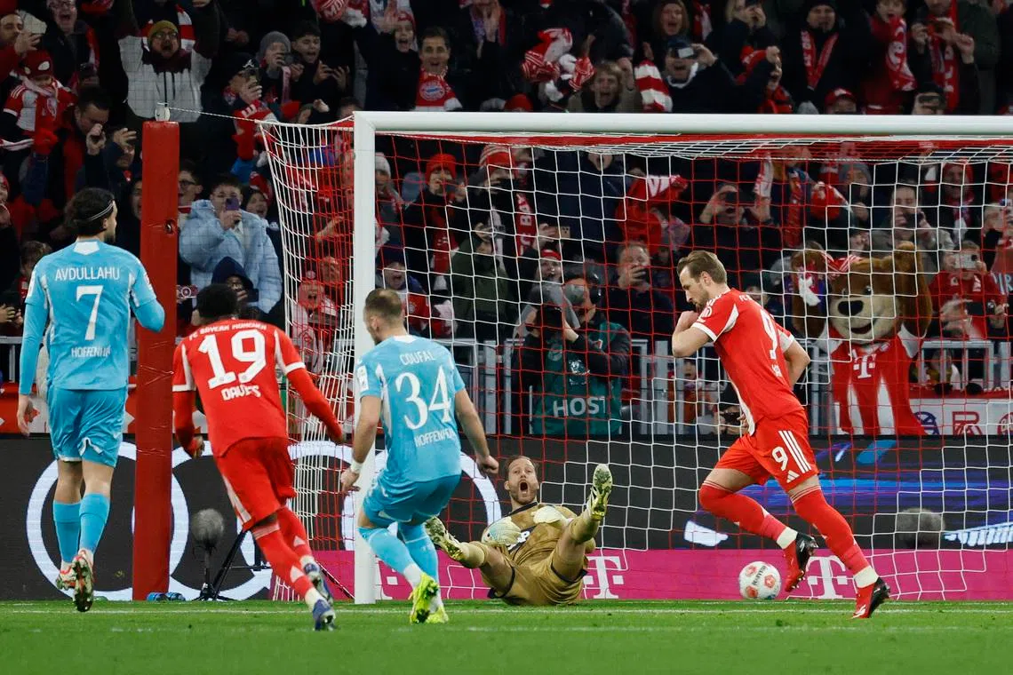 Soccer Football - Bundesliga - Bayern Munich v TSG 1899 Hoffenheim - Allianz Arena, Munich, Germany - February 8, 2026 Bayern Munich's Harry Kane celebrates scoring their first goal as TSG 1899 Hoffenheim's Oliver Baumann reacts REUTERS/Heiko B
