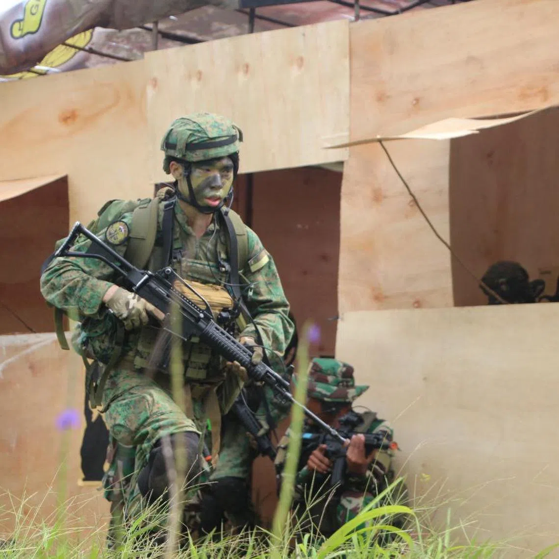 A commando from the Singapore Armed Forces advancing onto an objective alongside counterparts from Indonesia during Exercise Chandrapura.