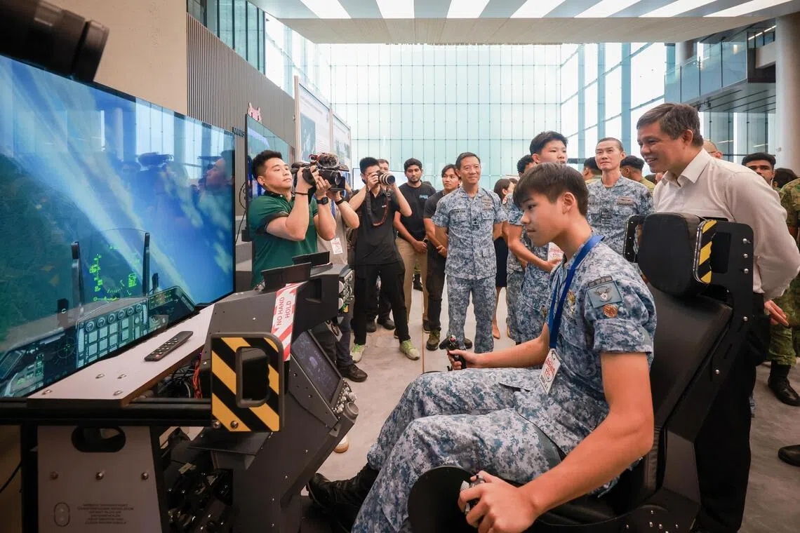 Minister for Defence Chan Chun Sing (right) viewing a F-16 flight simulator at the NCC 125th anniversary event on Aug 26.
