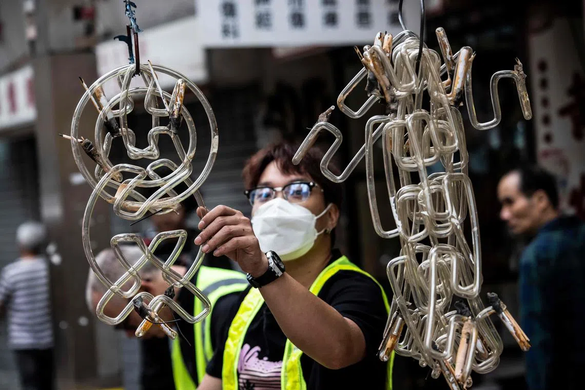 A worker sorting before wrapping the glass tubing from the Nam Cheong Pawn Shop neon sign during its removal at the requests of the government because of a change in regulations surrounding neon signs., March 13, 2023.