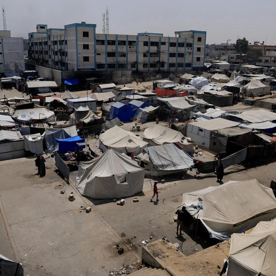FILE PHOTO: Palestinians displaced by the Israeli military offensive shelter in an UNRWA school, in Khan Younis, in the southern Gaza Strip, August 19, 2025. REUTERS/Hatem Khaled/File Photo