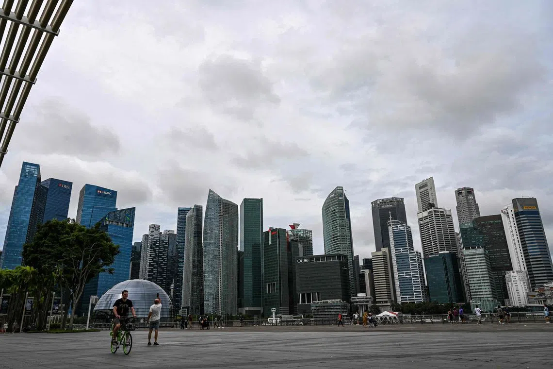People walk along the promenade at Marina bay in Singapore on February 1, 2023. (Photo by Roslan RAHMAN / AFP)