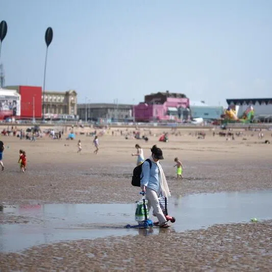 A person walks along the beach in Blackpool, Britain. The UK is experiencing a record-breaking heatwave, with temperatures exceeding 35 deg Celsius.