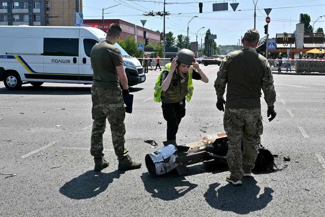 Officials examine fragments of a missile in Ukraine's capital, Kyiv, after Russia fired a barrage of missiles at the city. 