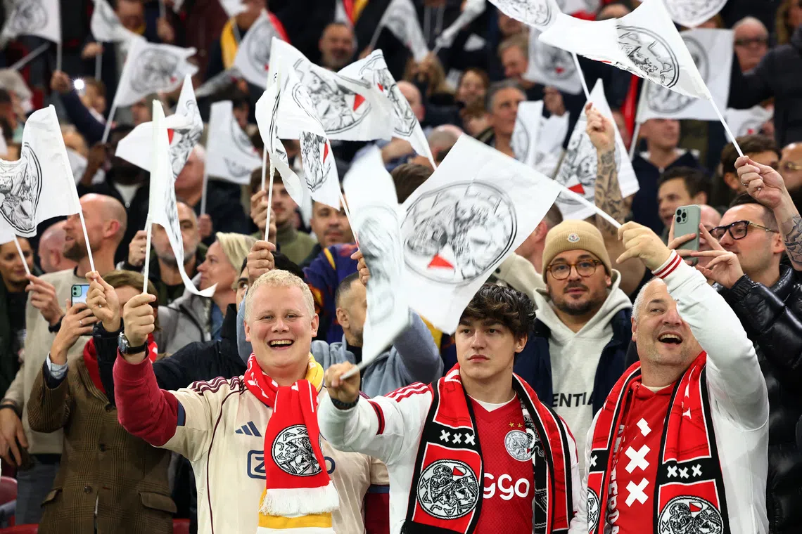 Soccer Football - UEFA Champions League - Ajax Amsterdam v Galatasaray - Johan Cruijff Arena, Amsterdam, Netherlands - November 5, 2025 Ajax Amsterdam fans wave flags inside the stadium before the match REUTERS/Piroschka Van De Wouw