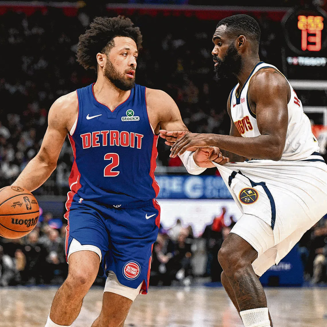 Detroit Pistons guard Cade Cunningham tugs on the shorts of Denver Nuggets guard Tim Hardaway Jr. before trying to drive past him in the second quarter at Little Caesars Arena.