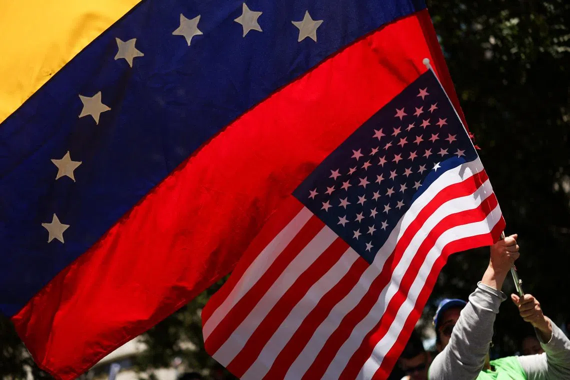 A person waves U.S. and Venezuela's flags as people celebrate following a U.S. strike on Venezuela where President Nicolas Maduro and his wife, Cilia Flores, were captured, in Santiago, Chile January 3, 2026. REUTERS/Pablo Sanhueza/File Photo
