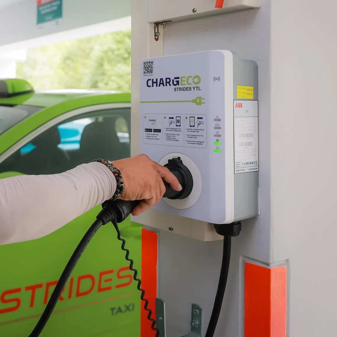 Strides taxi driver Francis Tan, 50, charging an his electric vehicle (EV) taxi at the ChargEco EV charging points at the multi-storey carpark at block 81 Telok Blangah Drive, 22 Feb 2023.