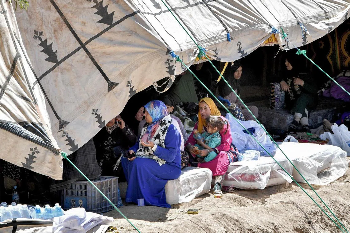 Survivors of the deadly 6.8-magnitude earthquake gathering under a tent in the village of Tikht near Adassil in central Morocco, on Sept 10, 2023. 
