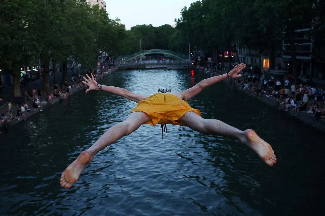 A man diving into the water in the Canal Saint-Martin as temperatures rise during a heatwave affecting a large part of the country, in Paris, France, on June 22.