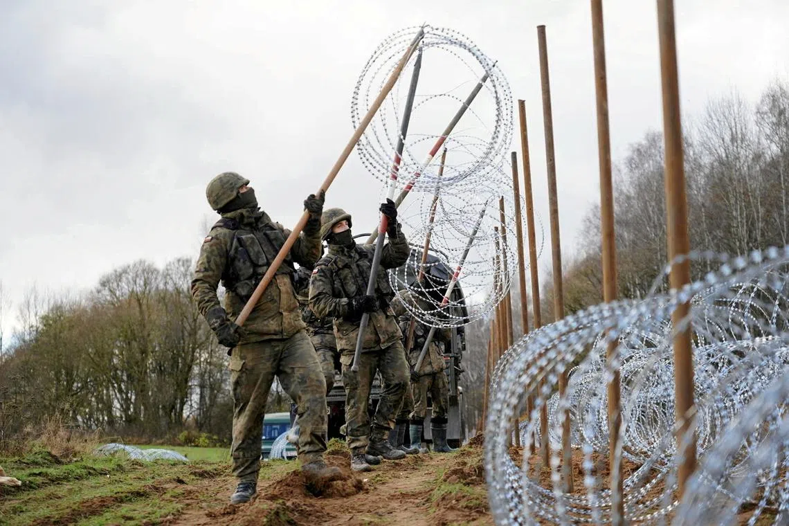 FILE PHOTO: Soldiers build razor wire fence on Poland's border with Russia's exclave of Kaliningrad near Bolcie, Poland November 3, 2022. Arkadiusz Stankiewicz/Agencja Wyborcza.pl via REUTERS /File Photo