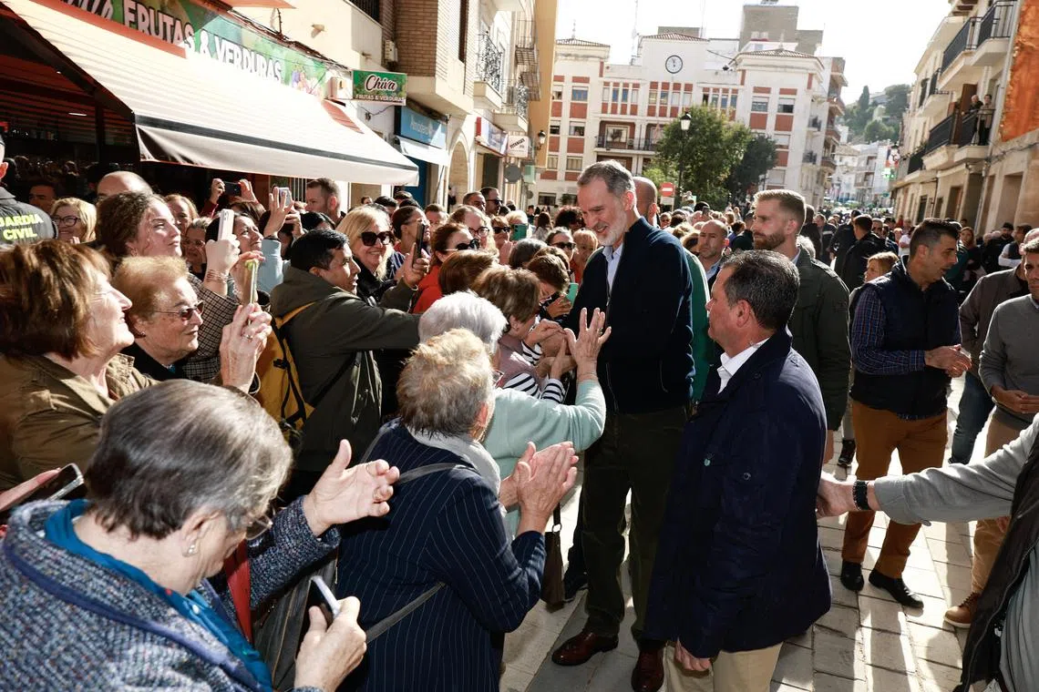 Spain's King Felipe (centre) talking to residents during the royal couple's visit to the flood-affected municipality of Chiva, Valencia, on Nov 19.