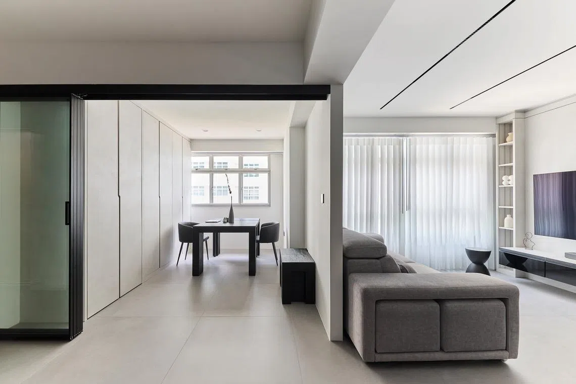 The living area and flexi-room of this HDB flat exude a sense of quiet serenity. 