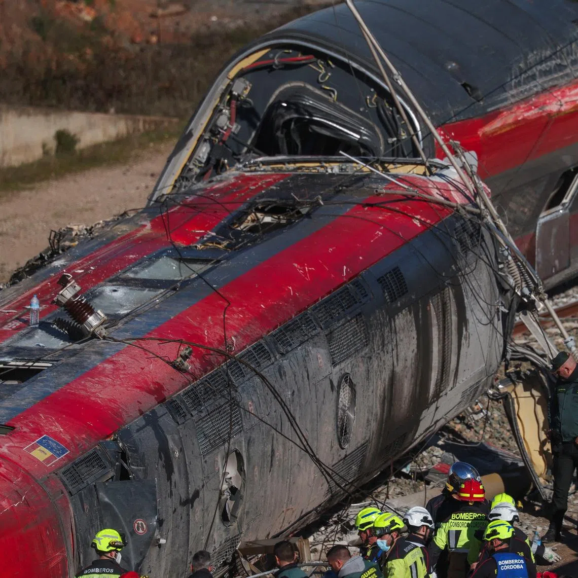 Members of the Spanish Civil Guard, along with other emergency personnel, work next to one of the trains involved in the accident, at the site of a deadly derailment of two high-speed trains near Adamuz, in Cordoba, Spain, January 19, 2026. REUTERS/Susana Vera