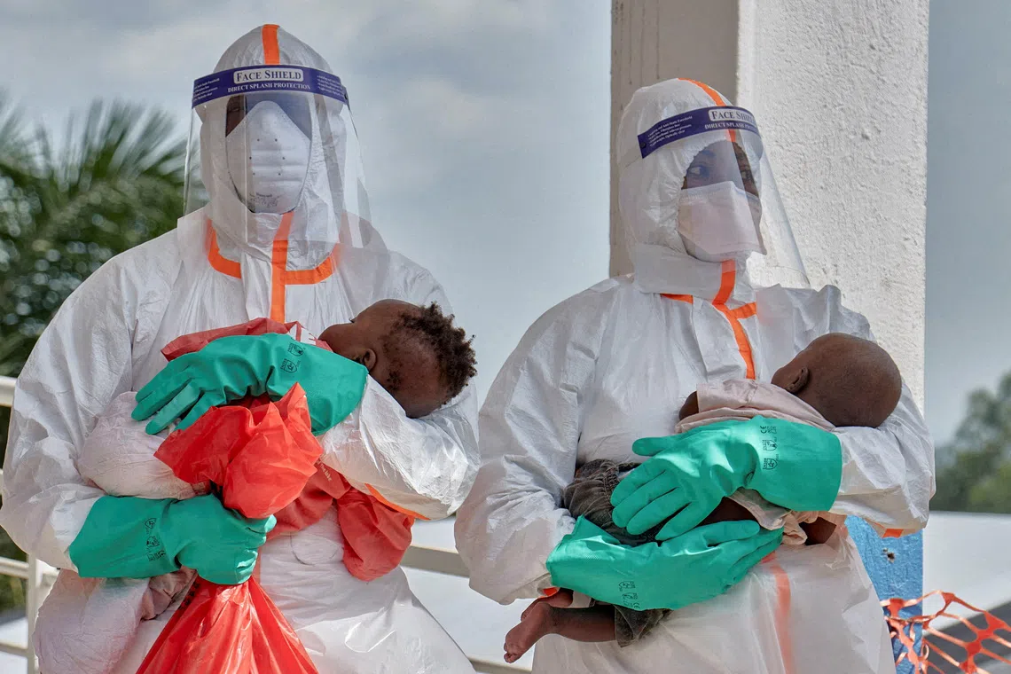 FILE PHOTO: Congolese medical workers dressed in personal protective equipment (PPE) carry children tested and cleared off from Ebola from Saint Nicholas orphanage, at the Centre Medical Evangelique (CME) within the secured Ebola response zone, as aid agencies intensify efforts to contain the Ebola outbreak involving the Bundibugyo strain, in Hoho commune of Bunia town, Ituri province, Democratic Republic of Congo, June 9, 2026. REUTERS/Gradel Muyisa Mumbere/File Photo