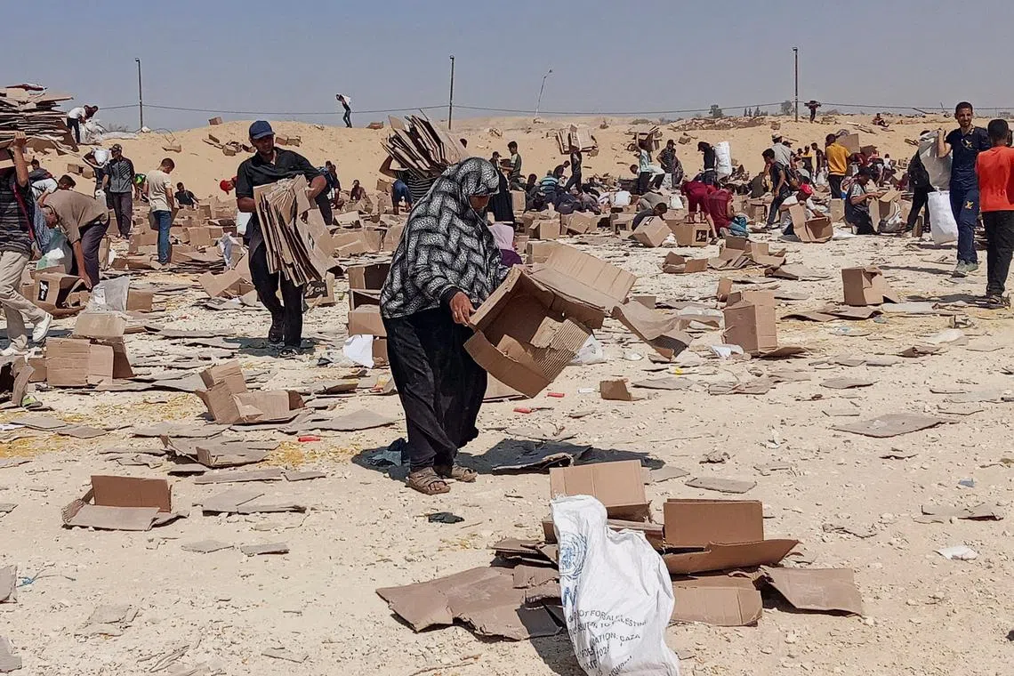 FILE PHOTO: Palestinians gather to collect what remains of relief supplies from the distribution center of the U.S.-backed Gaza Humanitarian Foundation, in Rafah, in the southern Gaza Strip, June 5, 2025. REUTERS/Stringer/File Photo