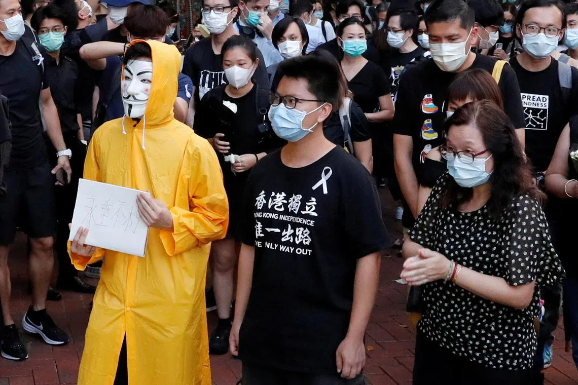 FILE PHOTO: Hong Kong activist dubbed \"Captain America 2.0\" Ma Chun-man (centre) attends a vigil for a protester Marco Leung Ling-kit who fell to his death during a demonstration outside the Pacific Place mall, in Hong Kong, China June 15, 2020. Picture taken June 15, 2020. REUTERS/Tyrone Siu/File Photo