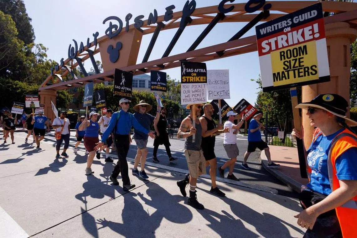 FILE PHOTO: SAG-AFTRA actors and Writers Guild of America (WGA) writers walk the picket line outside Disney Studios in Burbank, California, U.S., July 25, 2023.  REUTERS/Mike Blake/File Photo