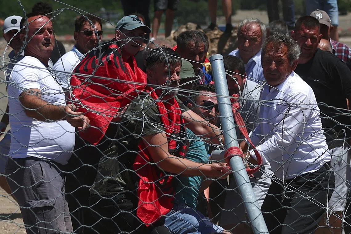 Protesters who say their land has been taken unjustly tear down the fence where a tourist resort is to be built by the Adriatic coast, in Rrjoll, near Shkodra, Albania, June 13, 2026. REUTERS/Florion Goga