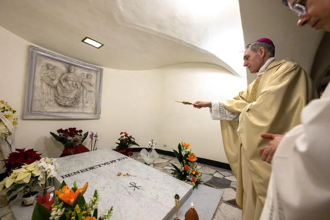 Former Pope Benedict's closest aide and private secretary, Archbishop Georg Ganswein, prays over the the tomb of Pope Emeritus in St. Peter's Basilica, at the Vatican, December 31, 2023.    Vatican Media/­Handout via REUTERS