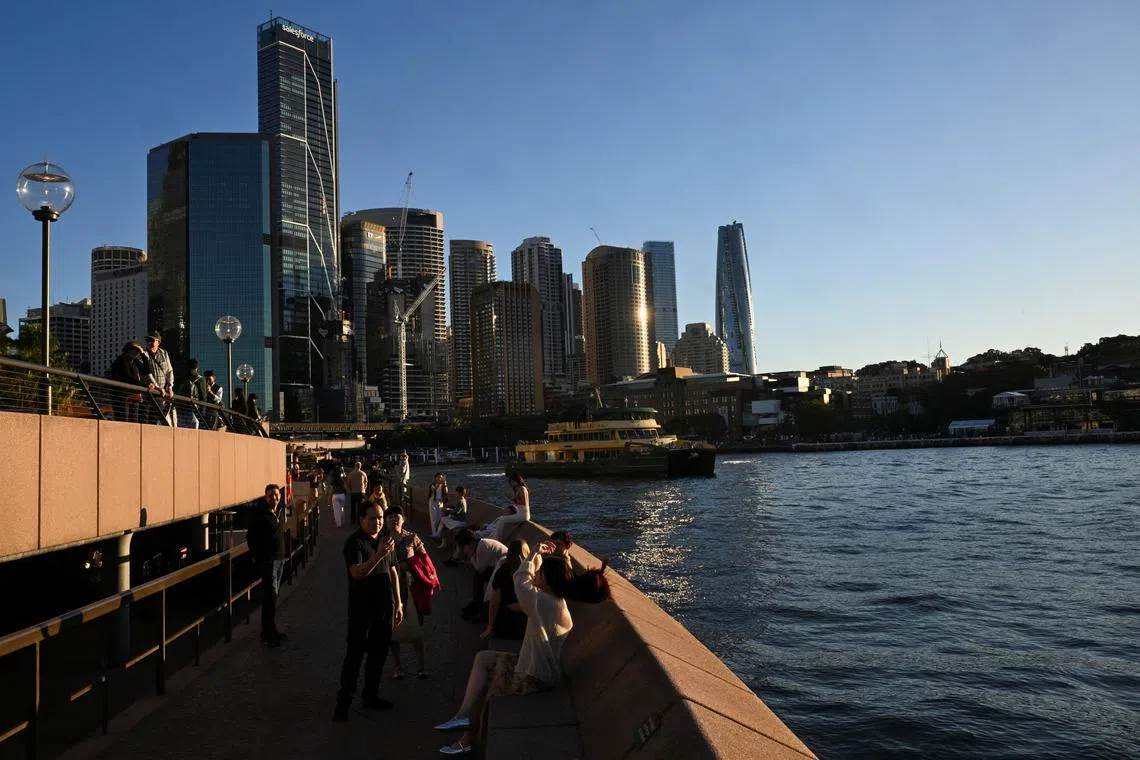 FILE PHOTO: People take photos by the Sydney Harbour, in Circular Quay, Sydney, Australia, May 14, 2024. REUTERS/Jaimi Joy/File Photo