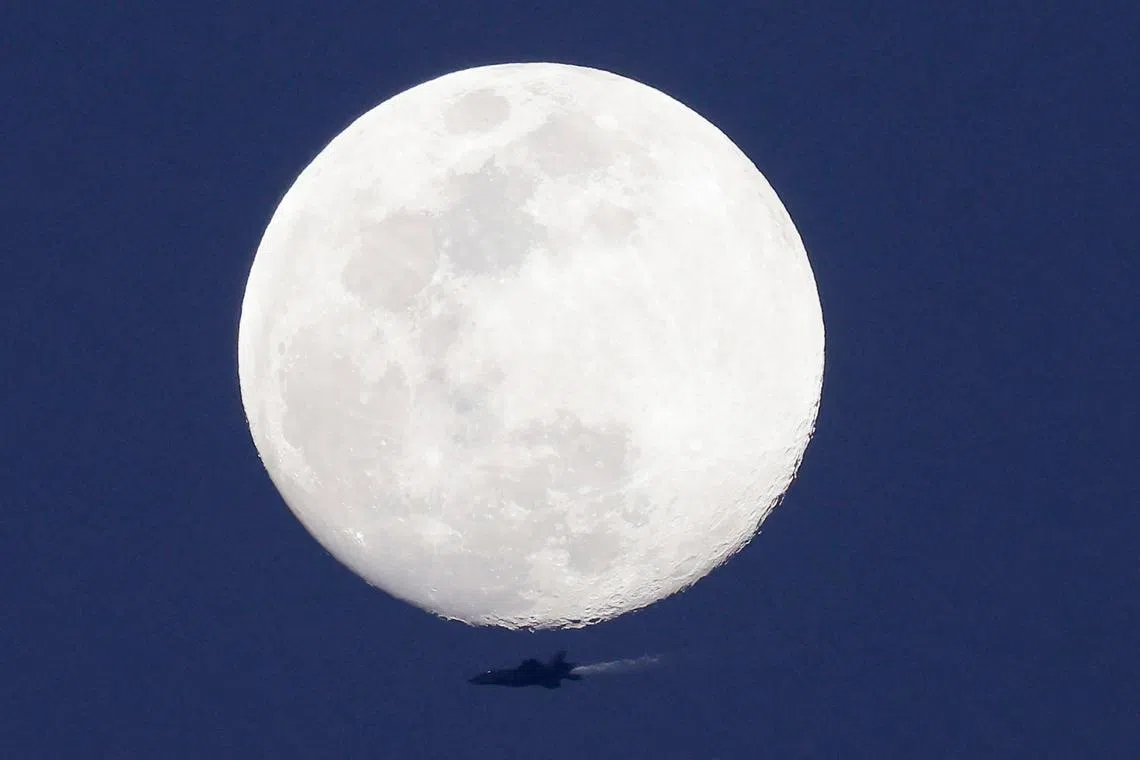 The Waxing Gibbous moon rises as an Israeli Air Force fighter aircraft flies over the border area with south Lebanon in northern Israel on Feb 22. The Iran-backed Hezbollah movement and its arch-foe Israel have been exchanging near-daily fire across the border since the Israel-Hamas war broke out on Oct 7. 
