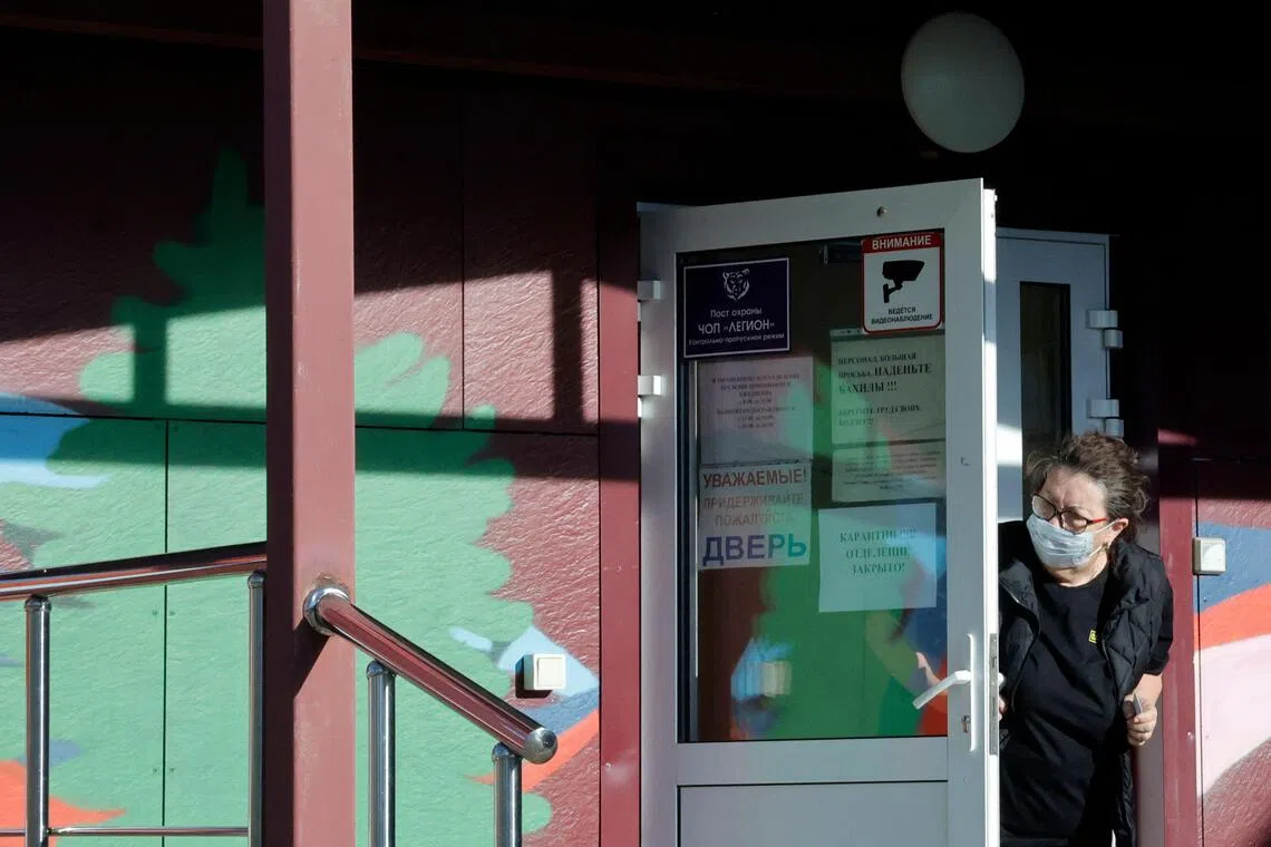 A security official wearing a face mask looks out from the door of an infectious diseases hospital in the town of Shelekhov - where an employee of the Irkutsk Antiplague Research Institute died - in the Irkutsk region of Russia on Oct 7.